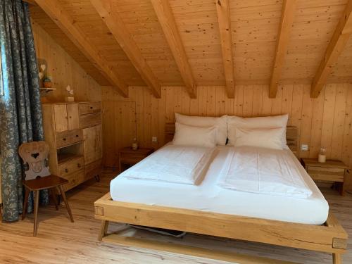 劳特布龙嫩Ferienwohnung Talhaus的木制客房内的一间卧室,配有一张床