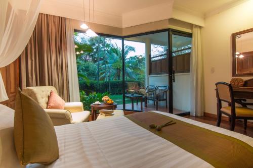 暹粒暹粒宫殿别墅酒店的一间卧室设有一张床和一间客厅。