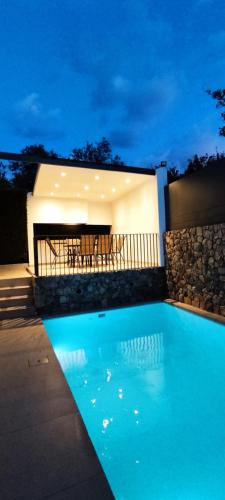 拉夫蒂港Villa Porto - Βίλα με ιδιωτική πισίνα的夜间在房子前面的游泳池