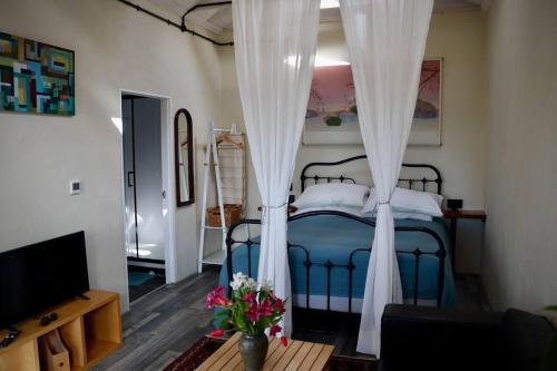 比迪福德Cosy cottage near Hartland Village的一间卧室配有蓝色的床和白色窗帘