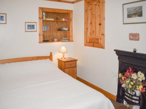 OllachThe Cottage的卧室配有白色的床和壁炉
