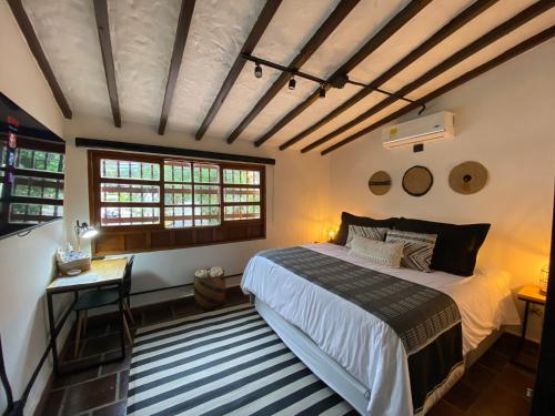 麦德林Casa Medallo的卧室配有一张床、一张书桌和窗户。