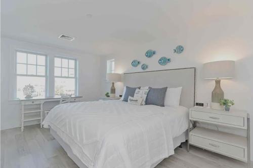 普里茅斯Harbourtown Suite Water View的白色的卧室配有一张白色的大床和一张书桌