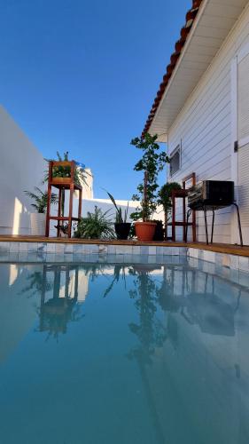 Balneário GaivotasA Casinha de Madeira的一座带两把椅子的房子前的游泳池
