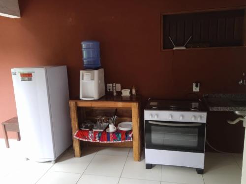 瓜拉米兰加Pousada Raízes Guaramiranga的厨房配有白色炉灶和冰箱。