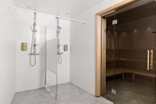埃斯基尔斯蒂纳贝斯特韦斯特广场酒店的浴室里设有玻璃门淋浴