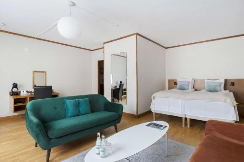 埃斯基尔斯蒂纳贝斯特韦斯特广场酒店的客厅配有绿色沙发和床。