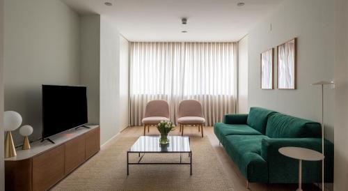 圣塞瓦斯蒂安The Passage Apartments的客厅配有绿色沙发和电视
