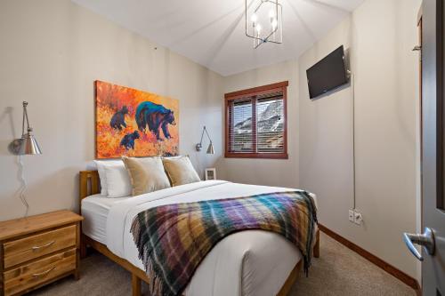 坎莫尔RidgeView Loft - Top Floor 2 Bed 2 Bath, Amazing Views的卧室配有一张床,墙上挂有绘画作品
