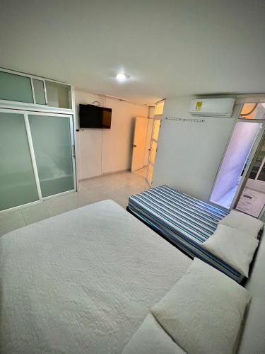 巴耶杜帕尔Acogedor apartamento amoblado con parqueadero的小房间设有床铺和电视