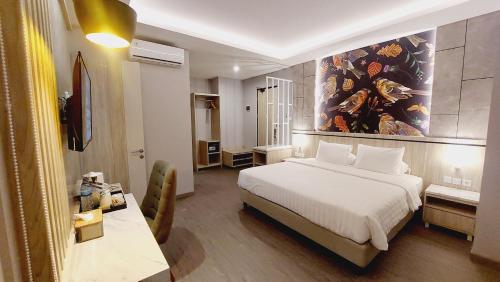 查亚普拉SIP Azana Hotel Jayapura的卧室配有一张床,墙上挂着一幅大画