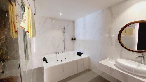 查亚普拉SIP Azana Hotel Jayapura的白色的浴室设有浴缸和水槽。