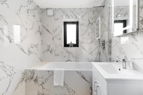 斯劳Modern 4 Bedroom House With Parking in Farnham Royal, Slough By Ferndale的白色的浴室设有水槽和镜子