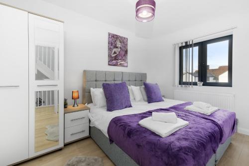 斯劳Modern 4 Bedroom House With Parking in Farnham Royal, Slough By Ferndale的一间卧室配有一张紫色的床和镜子