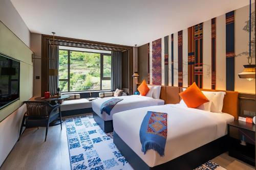 九寨沟九寨英迪格酒店的酒店客房设有两张床和窗户。
