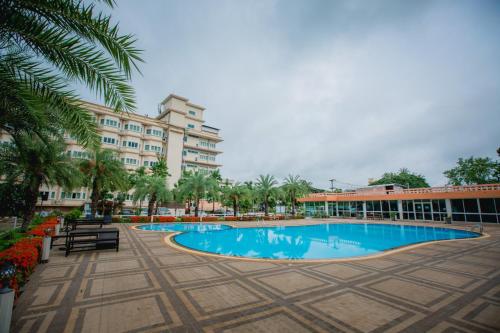 乌隆他尼斯艾姆格昂德酒店的一座带游泳池的度假村,位于一座建筑前