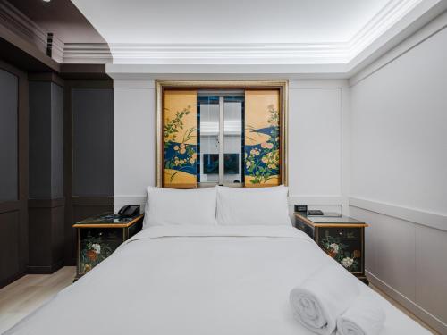 台北芝山璞旅的卧室配有白色的床和窗户。