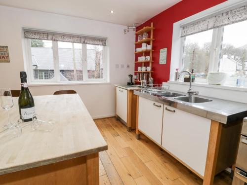 兰贝里斯Ty Coch的厨房设有红色的墙壁和带水槽的台面