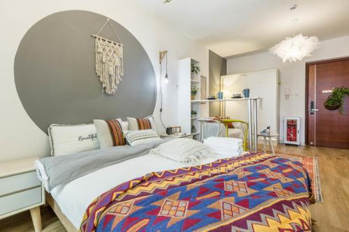 深圳WESU微宿轻奢公寓（深圳南山科技园店）的一间卧室配有一张大床和色彩缤纷的毯子