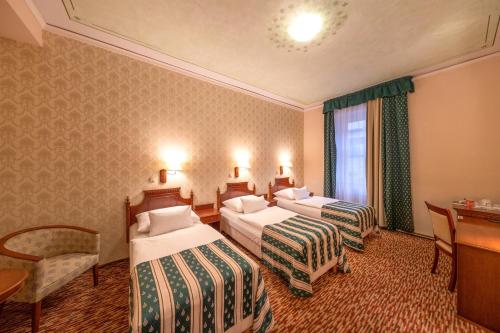 布拉格Hotel Meteor Plaza Prague的酒店客房配有两张床和一张书桌
