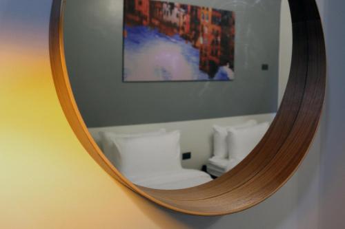 马尼拉mySTAY Hotel BGC North的镜子在墙上,反射出房间