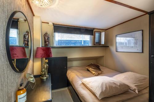 兹沃勒The luxury Boat的一间小卧室,配有一张床和镜子