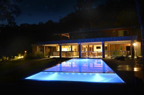 布拉伊Betikure Parc Lodge的一座晚上设有游泳池的房子