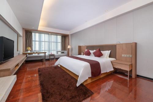 深圳深圳火车北站豪派特华美达广场酒店的一间卧室配有一张大床和一台平面电视
