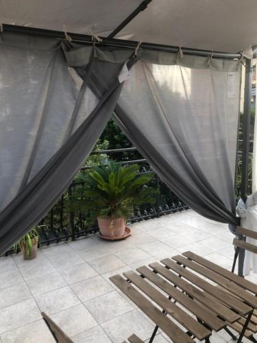 佩罗Appartamento con terrazza e posto auto Libri e Giardini的庭院,庭院里设有窗帘、长凳和植物