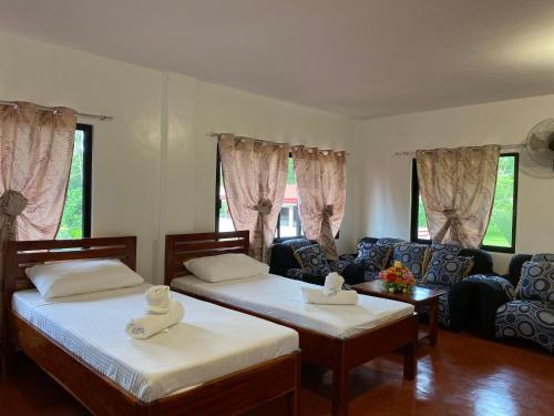 曼巴豪Tongatok Cliff Resort的一间带两张床和一张沙发的客厅