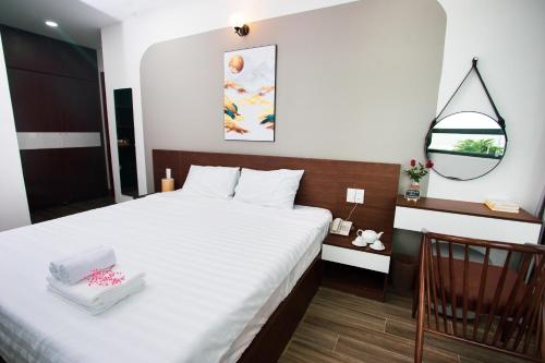 芽庄Tesoro Hotel的卧室配有一张带镜子的白色大床