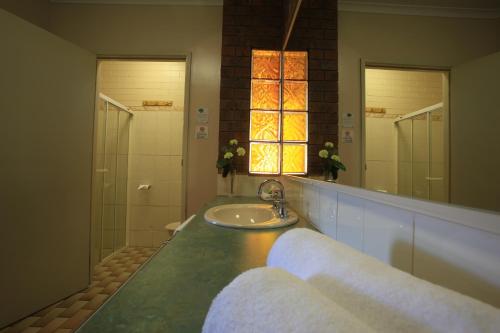 谢珀顿钟塔汽车旅馆的一间带水槽、淋浴和镜子的浴室