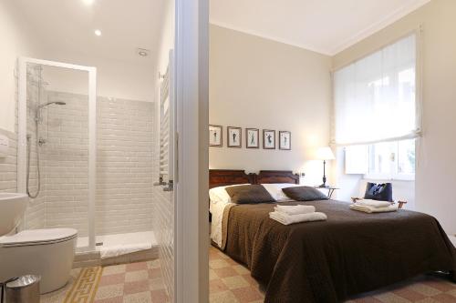 罗马马斯尼公寓的一间卧室配有一张床,浴室设有淋浴。