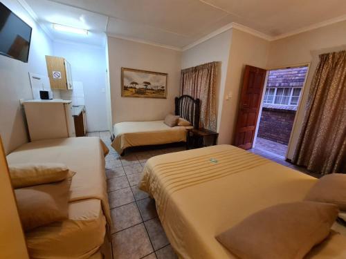 波罗瓜尼Motel Villa Africa的小酒店客房设有两张床和一张沙发。
