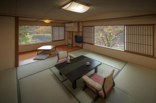 福岛晴海屋日式旅馆的客房设有桌椅和窗户。