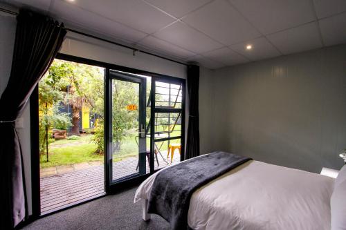 拉塞利亚SleepOver Lanseria的一间卧室设有一张床和一个大窗户