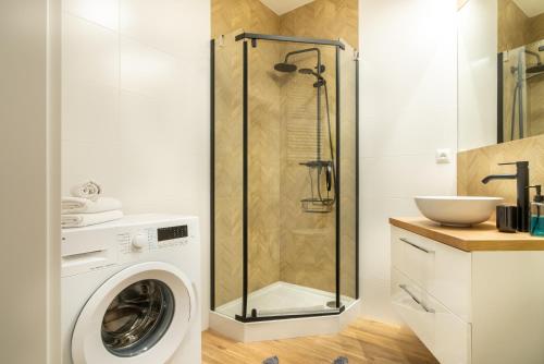 拉多姆ApartamentySnu, Struga Tower Gold z parkingiem的带淋浴的浴室和洗衣机。