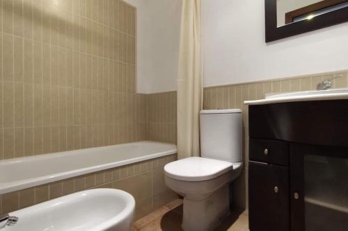 卡内拉岛Apartamento Los Pelícanos的浴室配有卫生间、盥洗盆和浴缸。