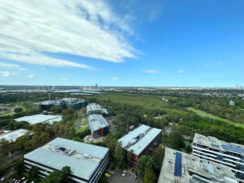 悉尼Best location apartment in Olympic park的城市的顶部景观,有建筑和树木