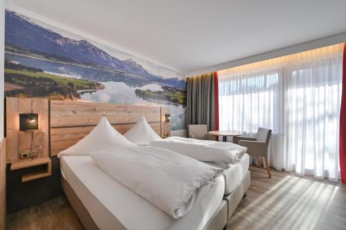 福森Hotel Ruchti - Zeit für mich的卧室配有一张大床,墙上挂有绘画作品