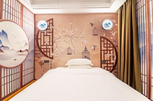 广州拼图酒店（中山八路陈家祠地铁站店）的一间卧室配有一张床,墙上挂有绘画作品