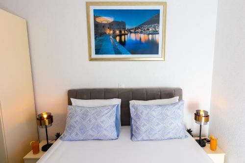 杜布罗夫尼克Apartment Rose Pool Comfort的一张带两个枕头的床,上面有一张图