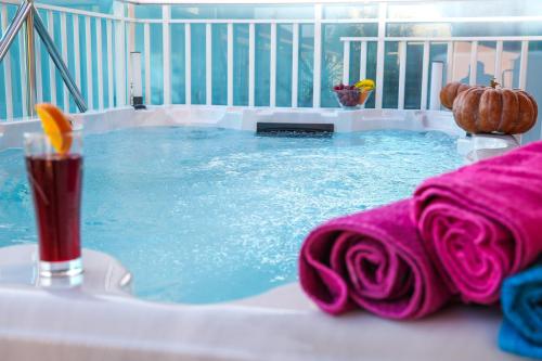 杜布罗夫尼克Apartment Rose Pool Comfort的热水浴池、饮料和粉红色毛巾