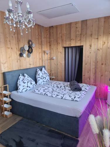 博登斯多夫Bambu Lodge @ Ossiachersee的一间卧室配有一张床和一个吊灯
