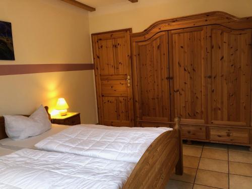 Groß KirrBirkenstr_17 EG的一间卧室配有一张床和一个大型木制橱柜