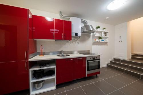 纳维廖河畔切尔努斯科Beat House&Apartments: ABBA的一间带红色橱柜和水槽的厨房