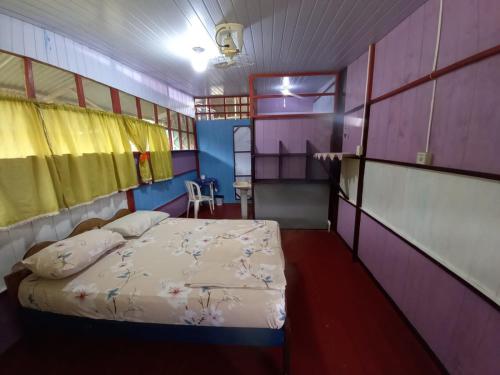 Puerto NariñoHostal tachiwa的紫色客房内的一间卧室,配有一张床