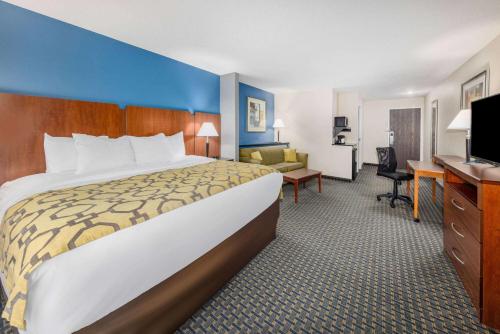 PrattBaymont by Wyndham Pratt的酒店客房设有一张大床和一张书桌。