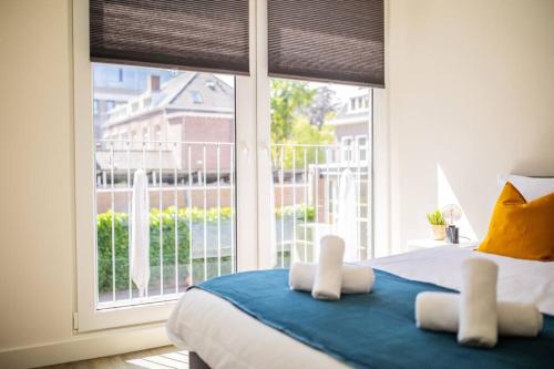 埃因霍温Lovely 3 Bedroom Apartment in Eindhoven 65m2的一间卧室设有一张床和一个大窗户