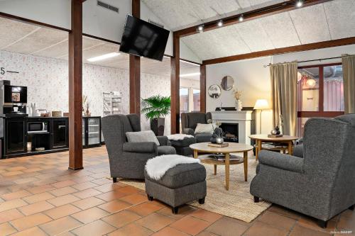 莫拉First Camp Moraparken Hotel的客厅配有几把椅子和电视
